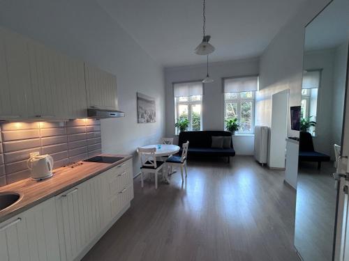 kuchnia i salon ze stołem i krzesłami w obiekcie Apartamenty Sobieski w mieście Sopot