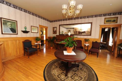 a living room with a table and a piano at Hôtel Château Albert in Bertrand