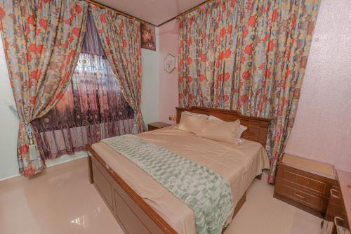 a bedroom with a bed and a window with curtains at UDUPI HOMESTAY Garden Villa in Udupi