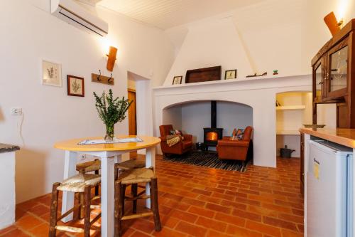 a kitchen and living room with a table and chairs at Monte do Pantaleão in Baleizão