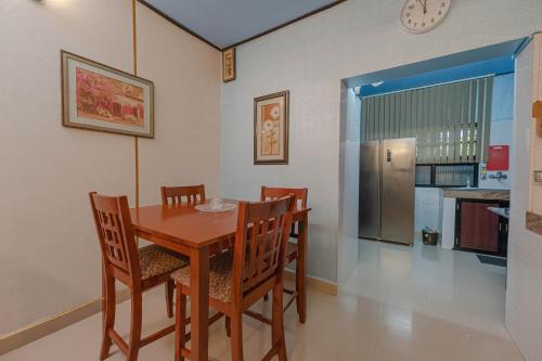 a dining room with a wooden table and chairs at UDUPI HOMESTAY Garden Villa in Udupi