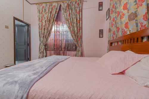 a bedroom with a large bed and a window at UDUPI HOMESTAY Garden Villa in Udupi