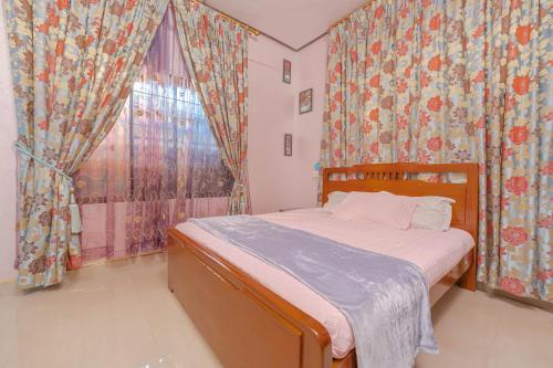 a bedroom with a bed and a window with curtains at UDUPI HOMESTAY Garden Villa in Udupi
