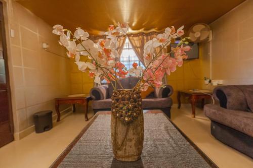 a vase with flowers in a living room at UDUPI HOMESTAY Garden Villa in Udupi