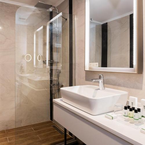 a white bathroom with a sink and a shower at The Emporia Hotel in Pamukkale