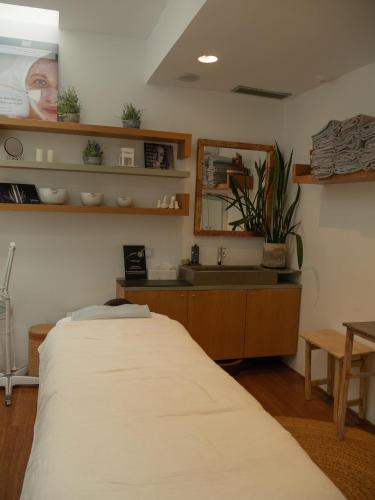 a bedroom with a bed and a sink and shelves at Hostal Empúries in L'Escala