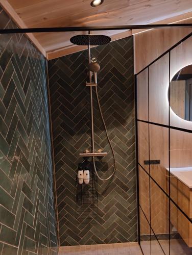 a shower in a bathroom with black tiles at Nye leiligheter på Blomberg i Hafjell in Hafjell