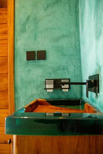 a sink in a bathroom with a green wall at Bahari View in Jambiani