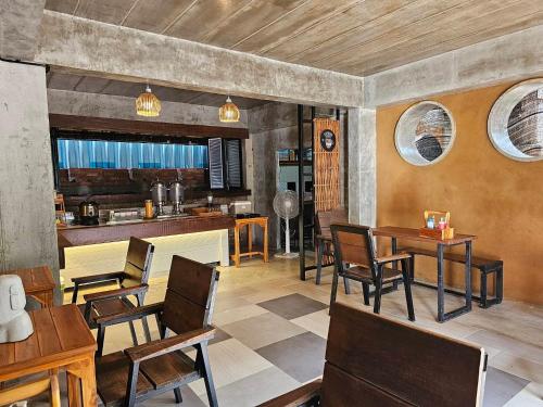 a dining room with tables and chairs and a kitchen at Life koh tao resort in Koh Tao