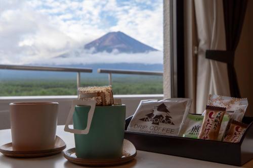 two cups on a table with a view of a mountain at Hotel Regina Kawaguchiko in Fujikawaguchiko