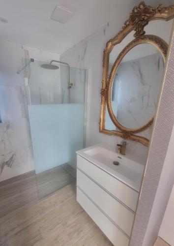 une salle de bain avec un lavabo blanc et un miroir dans l'établissement maison contemporaine, à Nîmes