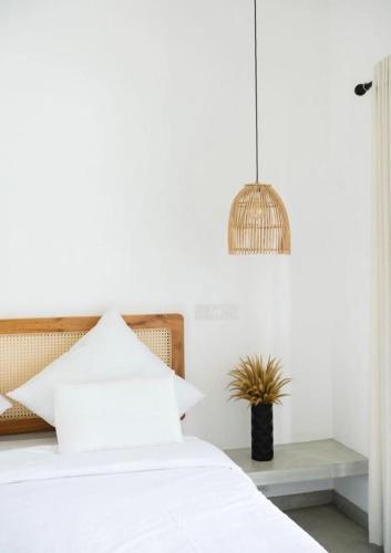 a bedroom with a white bed and a potted plant at Māna in Atadahewatugoda