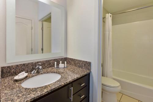 a bathroom with a sink and a toilet and a mirror at TownePlace Suites by Marriott Nashville Airport in Nashville