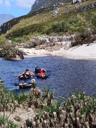 a group of people swimming in a river at Scenic Bliss Holiday Home in Kleinmond