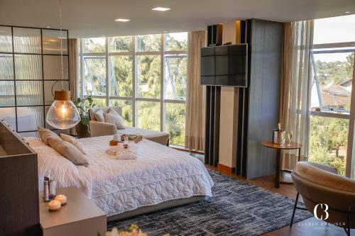 a bedroom with a bed and a large window at Casa Valduga Pousada Boutique in Bento Gonçalves