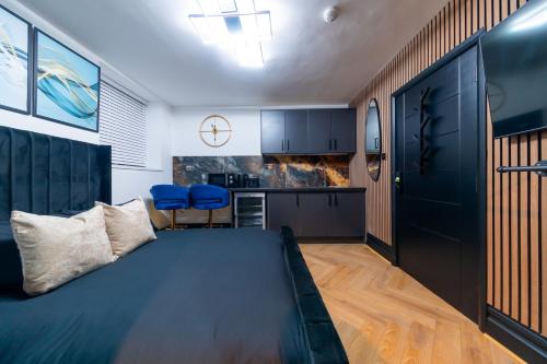 a bedroom with a large bed and blue chairs at MyNites in Birmingham