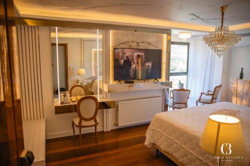a bedroom with a bed and a table and chairs at Casa Valduga Pousada Boutique in Bento Gonçalves