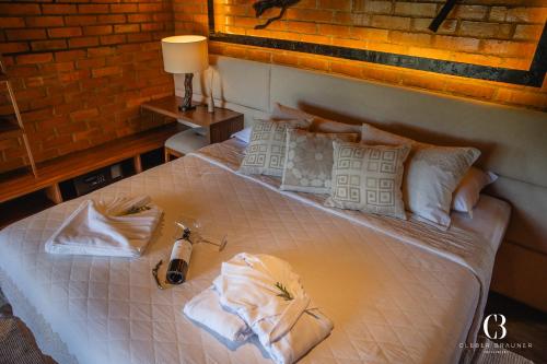 a bedroom with a bed with towels on it at Casa Valduga Pousada Boutique in Bento Gonçalves