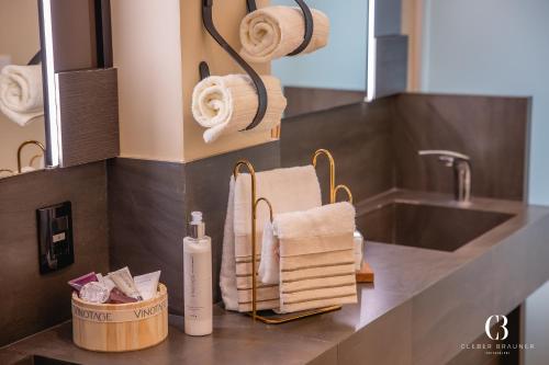 a bathroom counter with towels and a sink at Casa Valduga Pousada Boutique in Bento Gonçalves