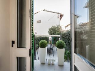 un balcón con 3 macetas y una puerta en Casa Rinuccini, en Florencia