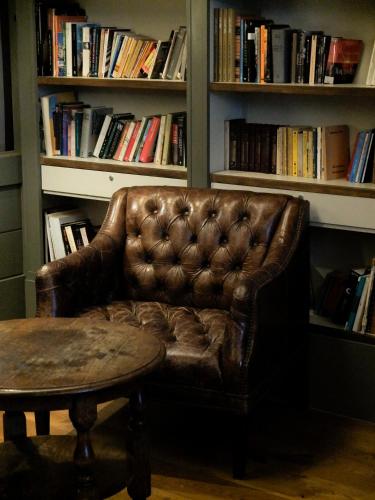 a brown leather couch in front of a book shelf at Hostal Empúries in L'Escala