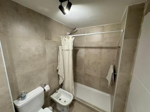 une salle de bain avec des toilettes blanches et une douche dans l'établissement Departamento Güemes, à San Carlos de Bariloche