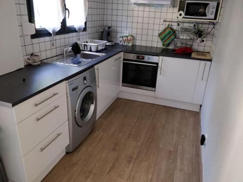 une cuisine avec un évier et une machine à laver dans l'établissement Logement entière F3, à Tremblay-en-France