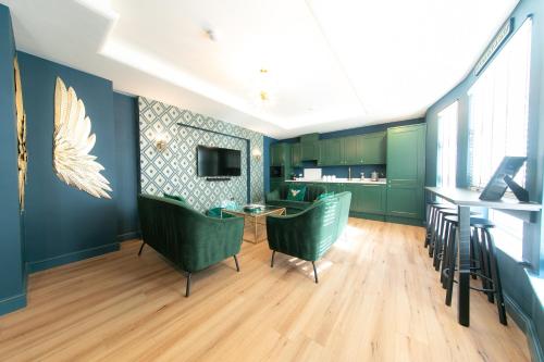 a living room with green chairs and a table at The Old Bank Apartments in Blackpool