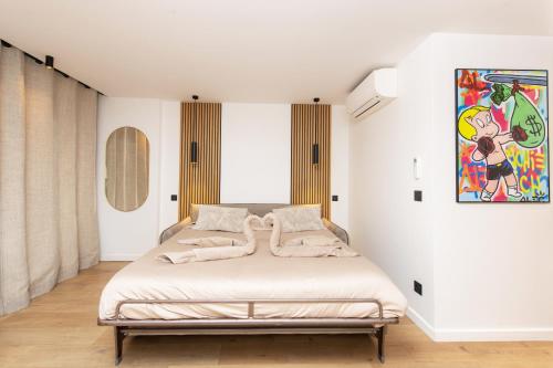 un lit dans une chambre avec un tableau sur le mur dans l'établissement PLAGE - Somptueux Studio - 50 m bord de mer- Proche Monaco, à Roquebrune-Cap-Martin