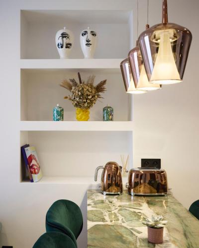 a kitchen with a marble counter top and white shelves at Le XV Cannes in Cannes