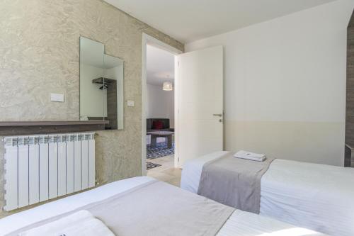 a bedroom with two beds and a mirror at Villagio Resort in Zaarour in Zaarour