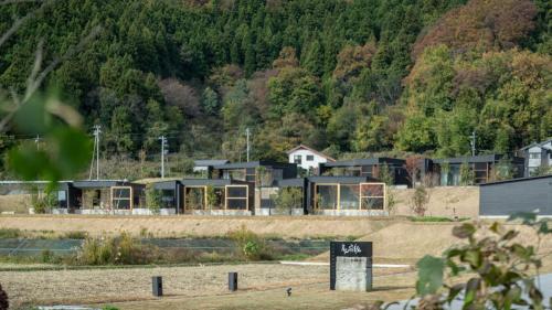 a group of houses on a hill with trees at 歓宿縁 eshikoto in Eiheiji
