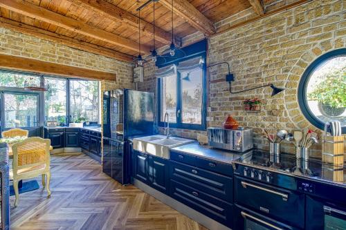 eine Küche mit blauen Schränken und einer Ziegelwand in der Unterkunft Villa des Berges - 7 Chambres et 6 Salles de bain in Bourbourg