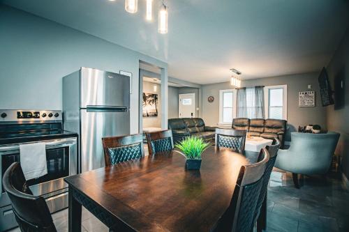 a kitchen and dining room with a table and a refrigerator at The Horseshoe Villa 6br 2 Bath near the falls in Niagara Falls