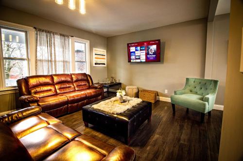 a living room with a leather couch and a chair at The Horseshoe Villa 6br 2 Bath near the falls in Niagara Falls