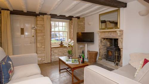 a living room with a couch and a fireplace at Mouse Manor in Longborough