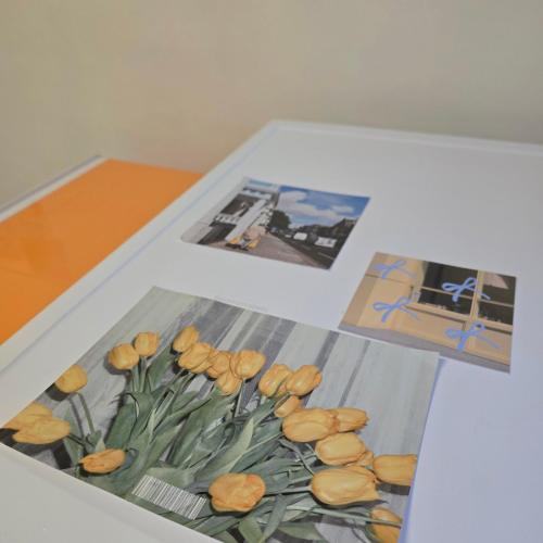 a table with two photographs and a picture of flowers at Comfort Seoul in Seoul