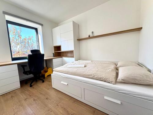 a bedroom with a bed and a desk and a window at Villa Senec in Senec