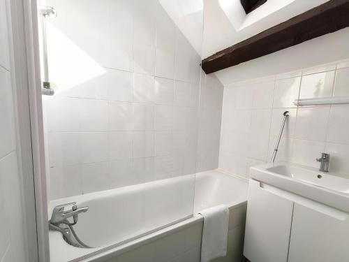 une salle de bain blanche avec une baignoire et un lavabo dans l'établissement Stanislas, à Rouen