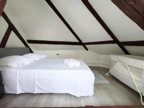 une chambre avec un lit blanc avec deux serviettes dessus dans l'établissement Stanislas, à Rouen