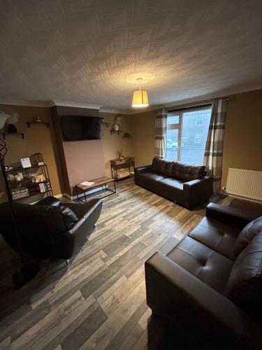 a living room with two couches and a table at Viewlands house in Auchterarder