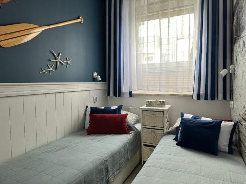 sypialnia z dwoma łóżkami i oknem w obiekcie Amko Style Apartamenty Nord 8 z ogródkiem Willa Nord w Jastrzębiej Górze
