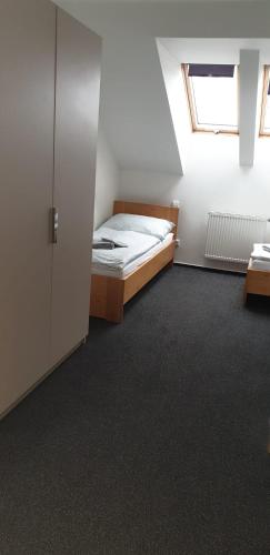 a small bedroom with a bed and a window at Penzion a Restaurace u Sousedů in Strážný