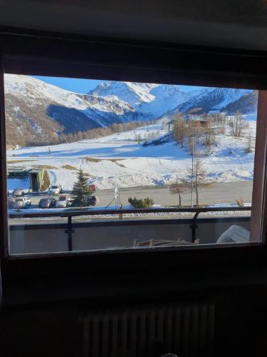 a view of a snowy mountain from a window at Sestriere Gem Comfy Apartment with Ski Views in Sestriere