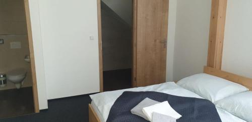 a bedroom with a bed with a towel on it at Penzion a Restaurace u Sousedů in Strážný