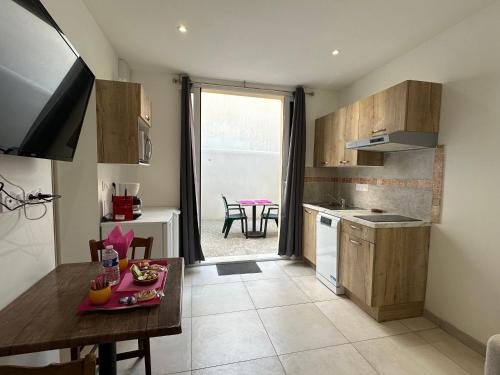 une cuisine avec une table et une salle à manger dans l'établissement Chez Camille & Emma - Climatisé, à Rochefort