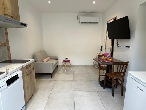 une cuisine et un salon avec un canapé et une table dans l'établissement Chez Camille & Emma - Climatisé, à Rochefort