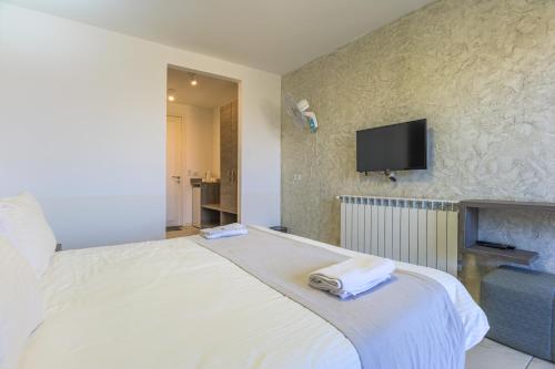 a bedroom with a bed and a tv on the wall at Villagio Resort in Zaarour in Zaarour