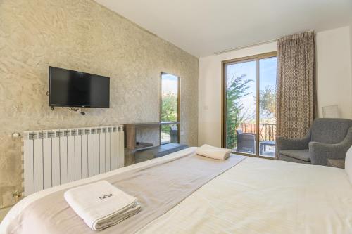 a bedroom with a large bed with a tv on the wall at Villagio Resort in Zaarour in Zaarour