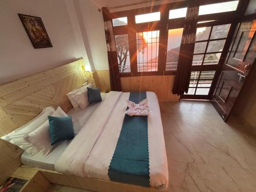a large bed in a room with a window at Vansathli I Near Mall Road Kasauli I Open Garden & Rooftop I by Humble stay villa in Kasauli